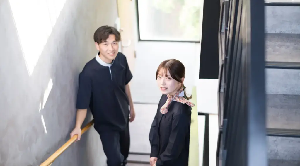 男性スタッフと女性スタッフ２名が笑顔でこちらをみている